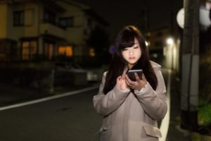 スマホ操作　女性の夜道一人歩き