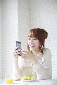 携帯でお部屋探しする女性