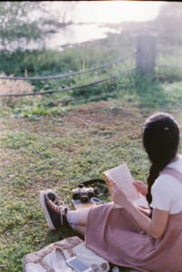 芝生で読書する女性