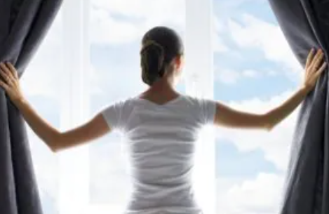 カーテンを開ける女性　防犯　窓